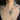 Person with tattoos on their chest wearing a gold necklace.