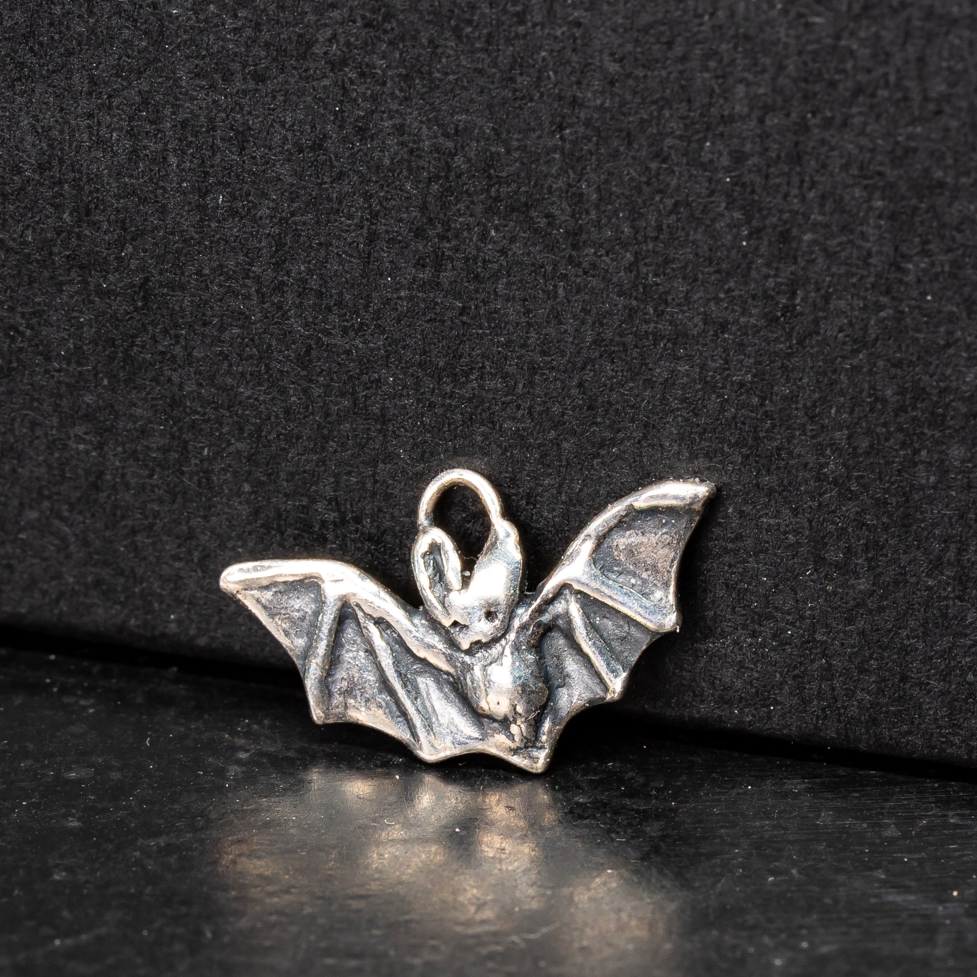 little sterling silver long-eared bat charm on a black background 