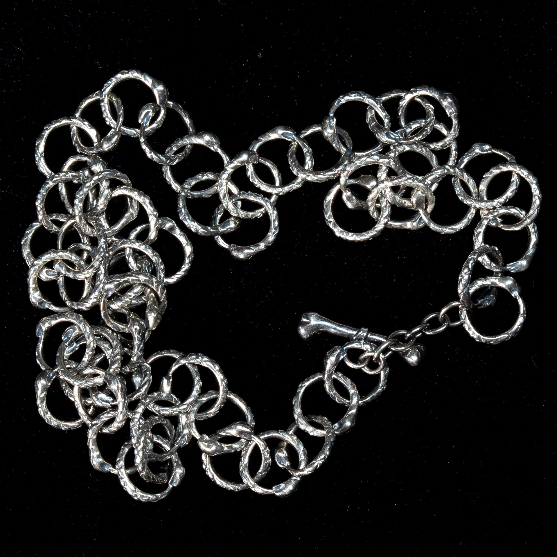 handmade baby snake  chain link necklace in sterling silver on a black background