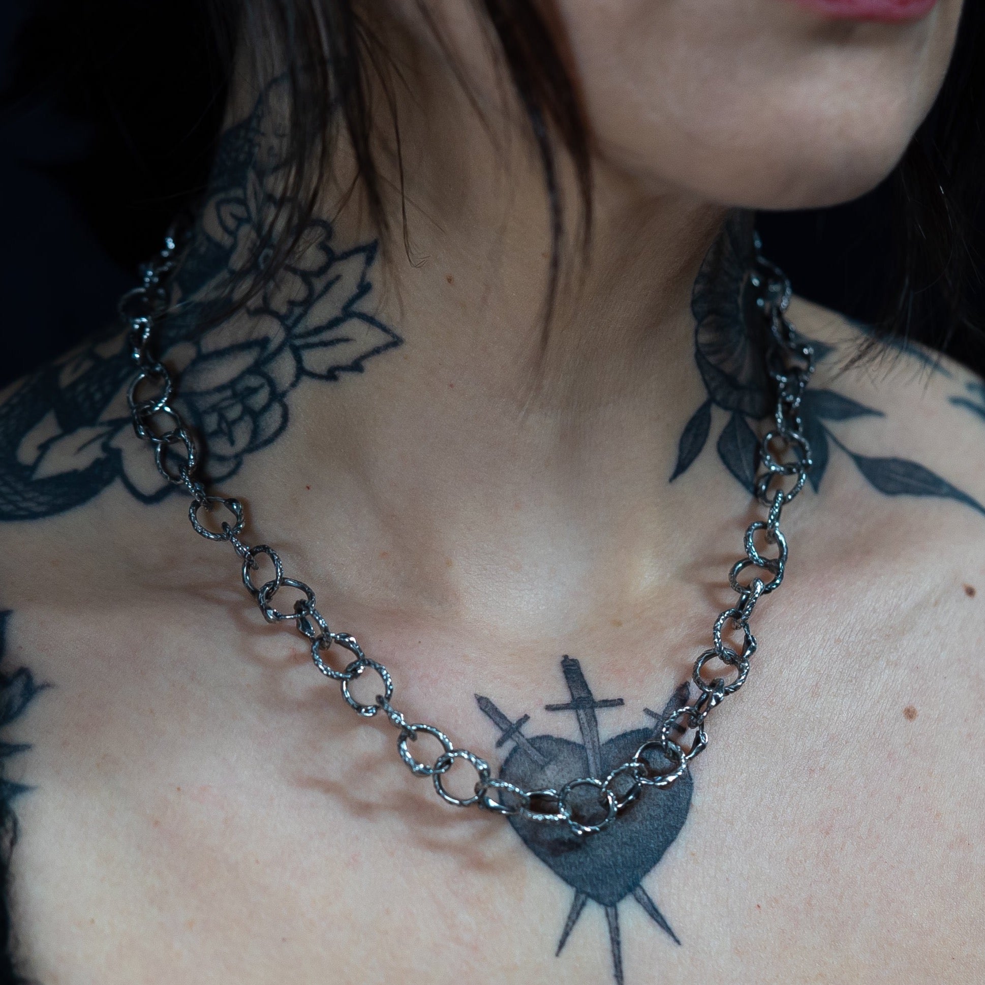 handmade baby snake chin link necklace in sterling silver on a gothic aesthetic style female model with neck tattoos