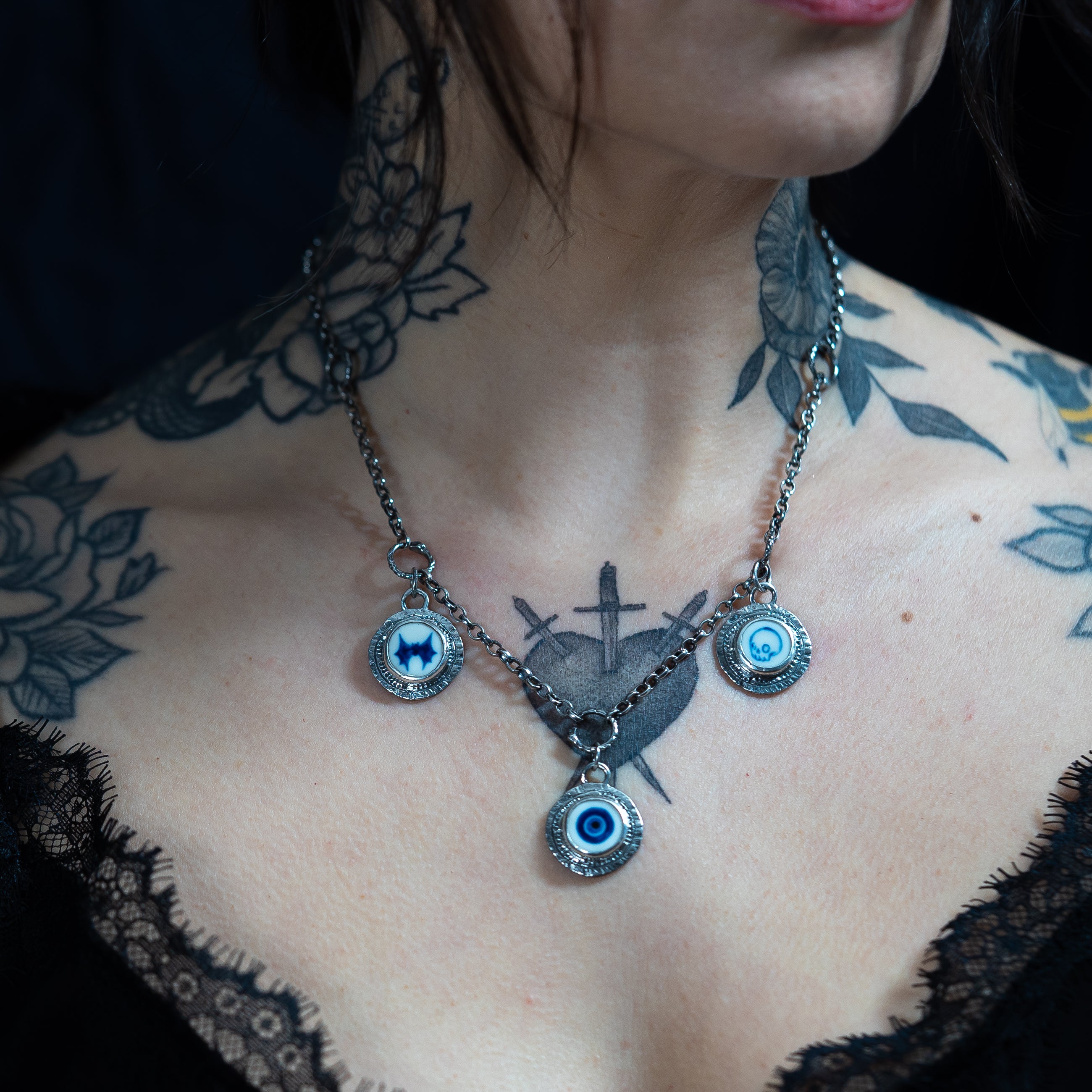 charm necklace with 3 hand painted porcelain and silver coin charms on a tattooed model