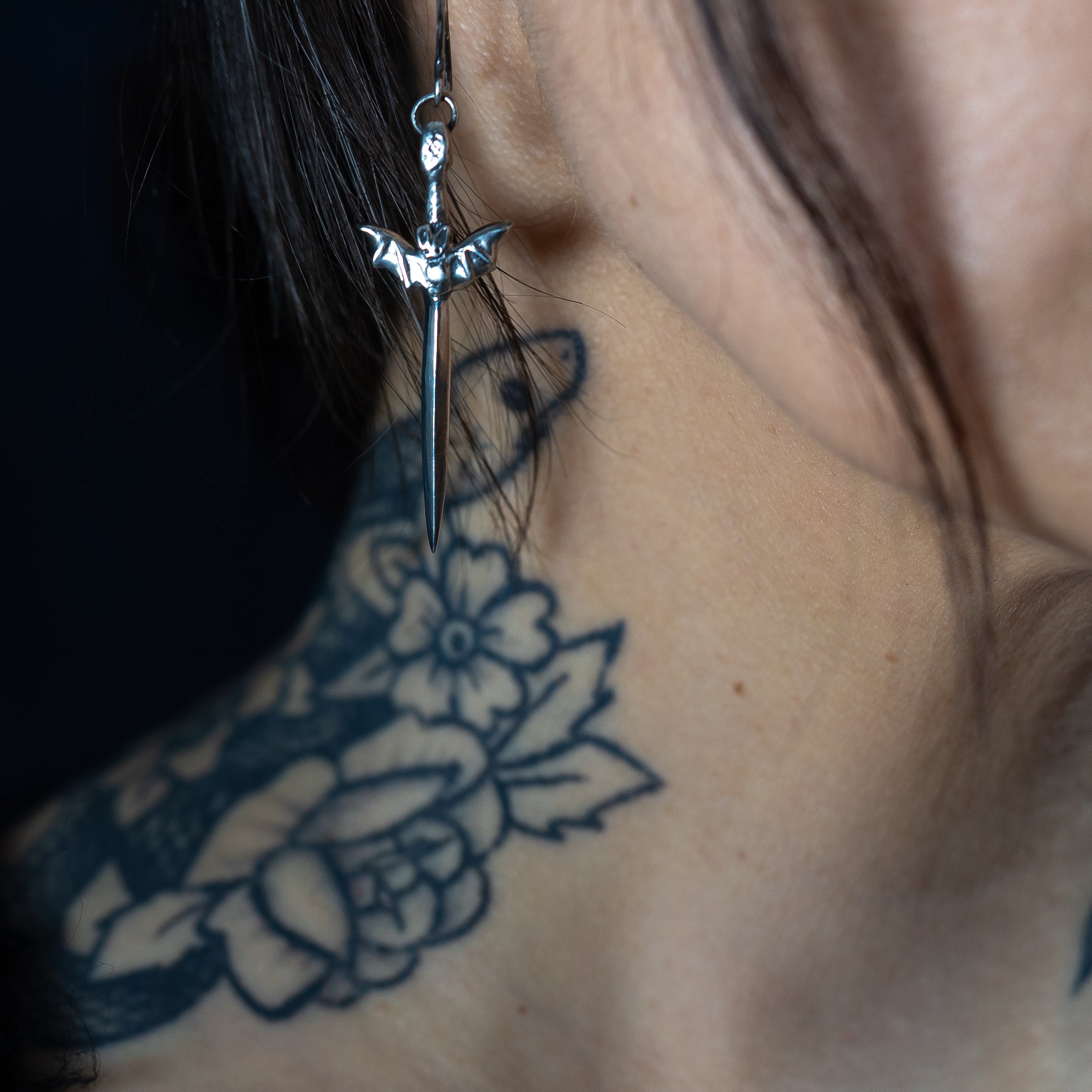 Alternative model wearing a bat dagger earring