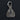 A silver planchette-shaped pendant charm featuring an eye of providence, crescent moons, and a snake bail, set against a dark textured background.