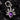 A sterling silver pendant featuring a teardrop-shaped amethyst gemstone with two skulls on either side and a crown above the stone, set against a black textured background.