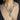 Necklace with a heart-shaped pendant worn by a person with tattoos on their neck.