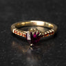Gold engagement ring with heart shaped garnet and shoulders of scallop set garnets.