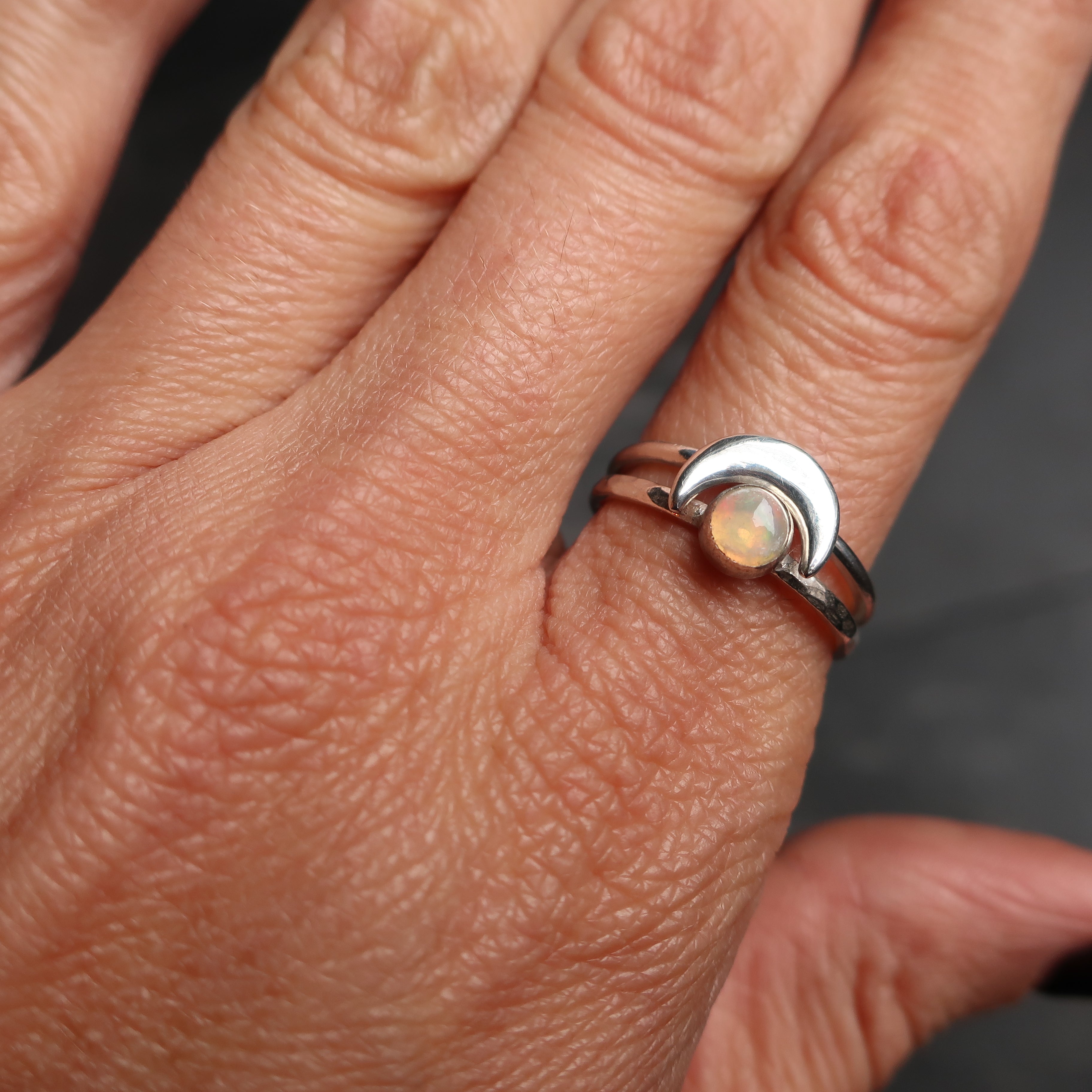 hand model wearing crescent moon and satellite  silver stacking rings