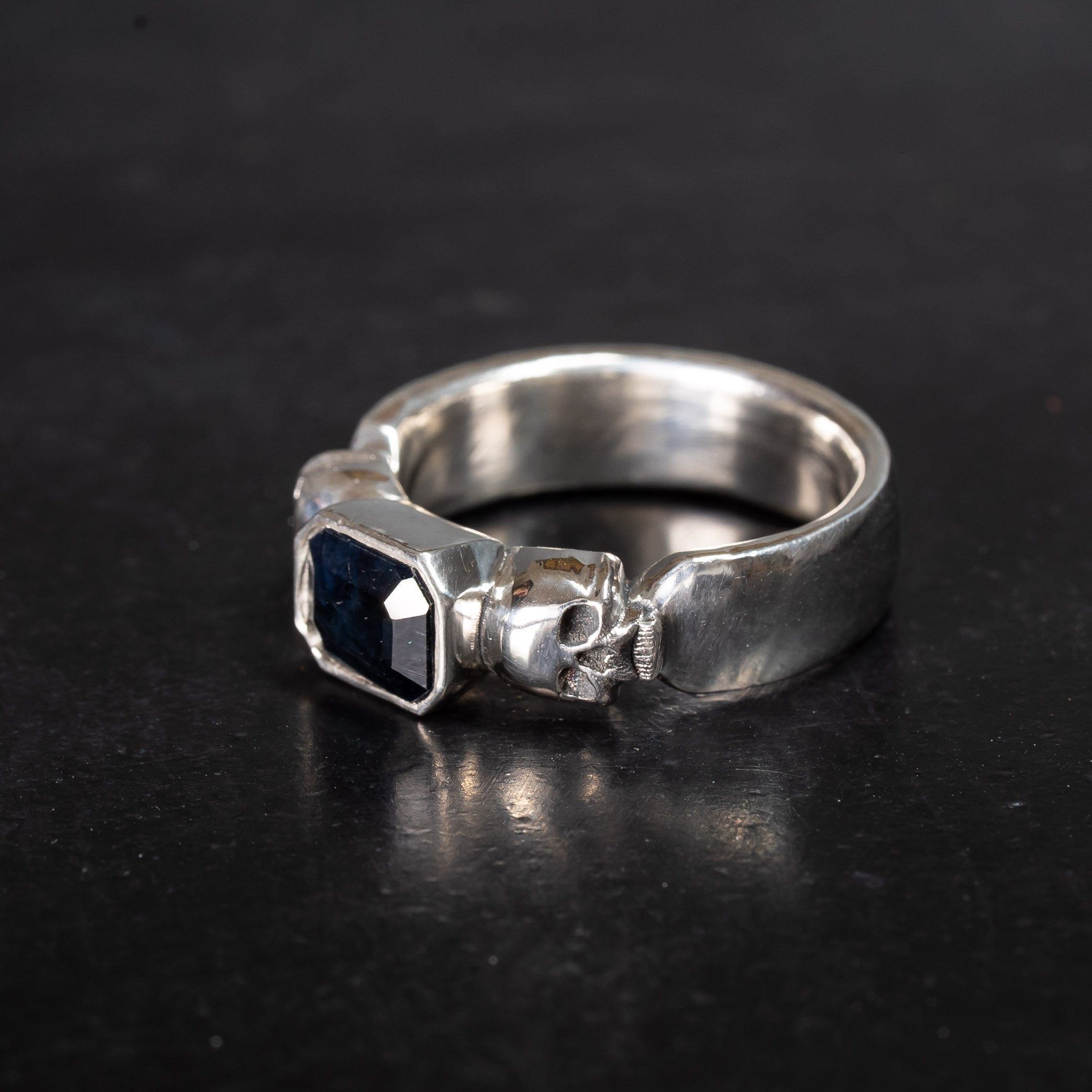 Hades ring with Black Sapphire nested between two skulls
