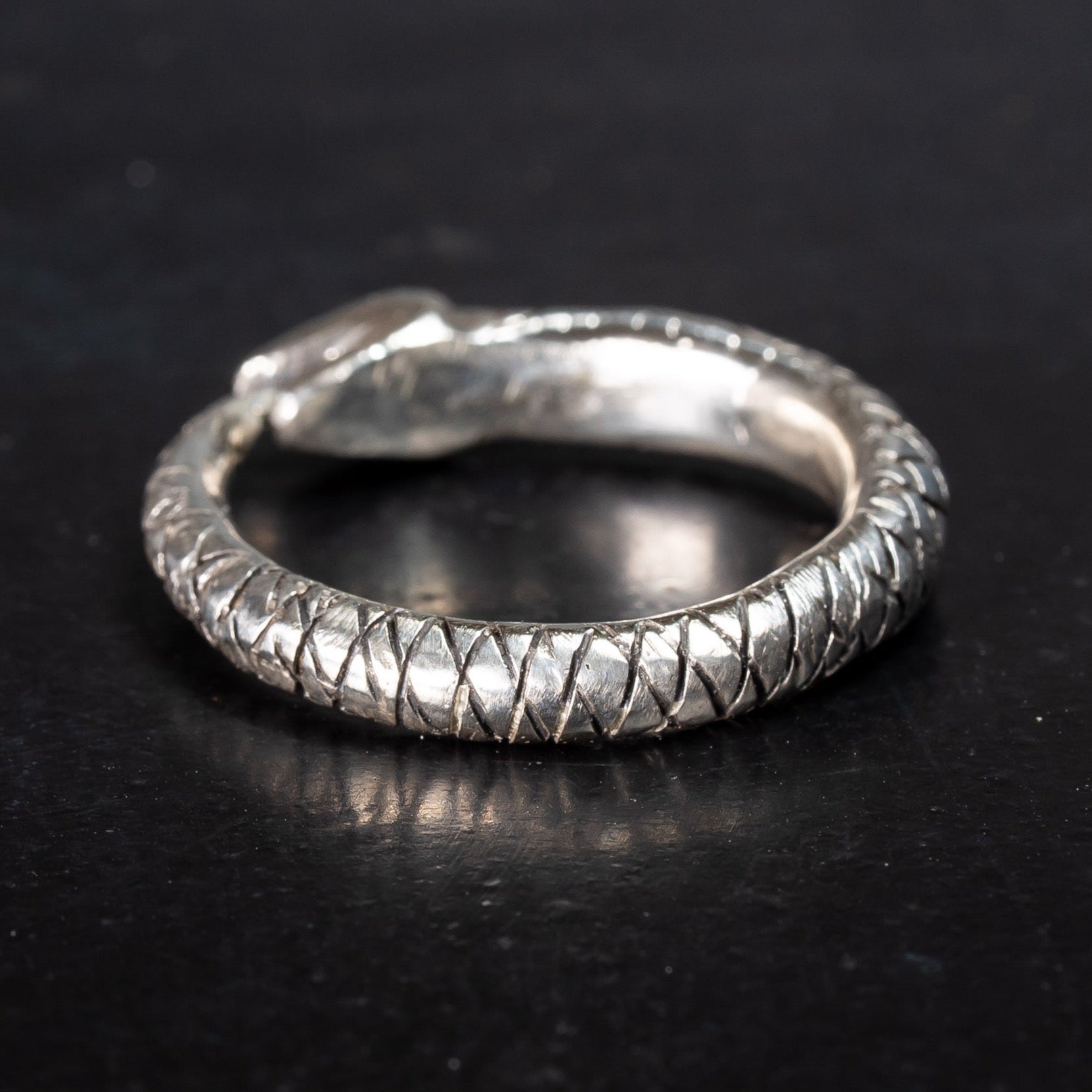 scaly sterling silver snake ring, ouroboros snake eating its own tail on black background