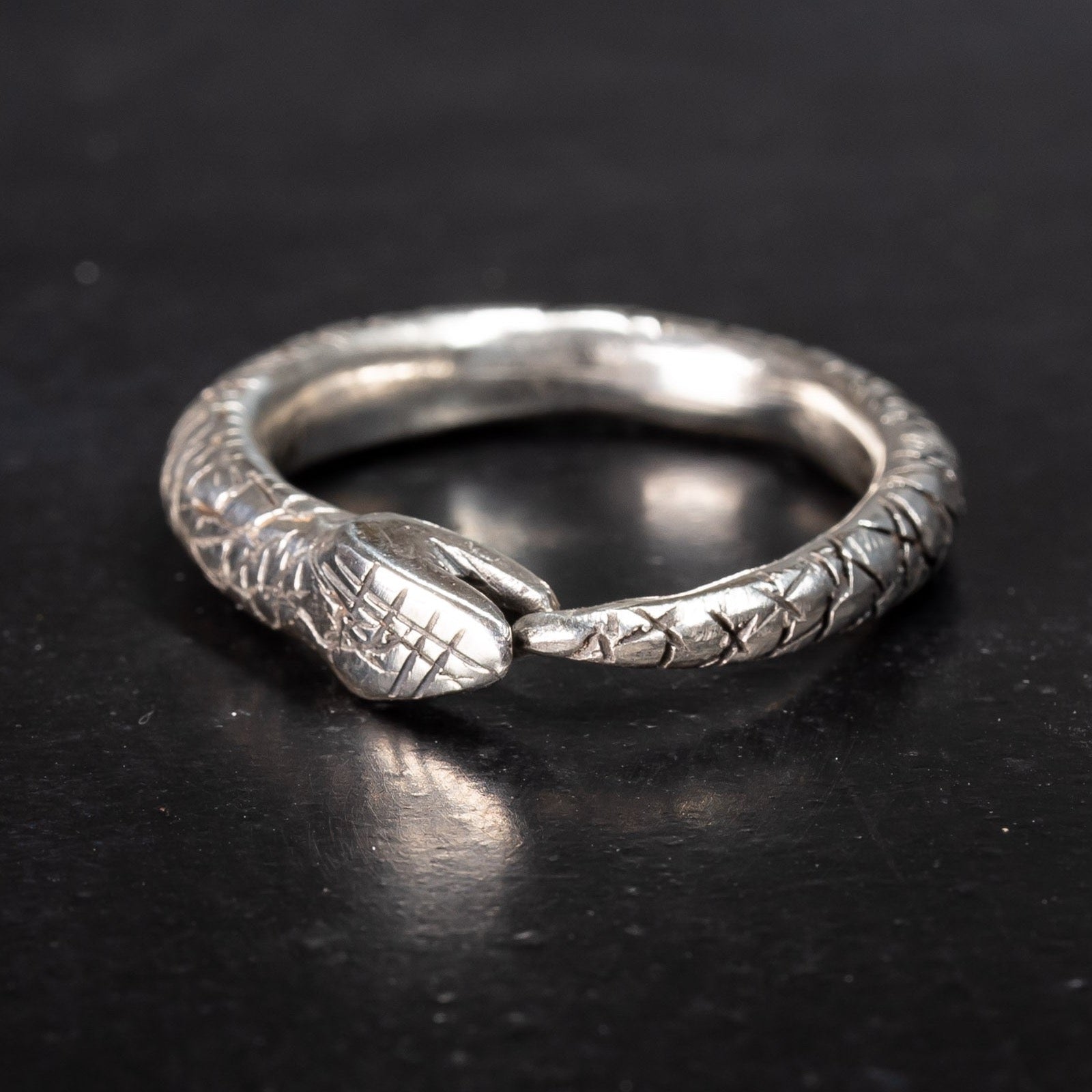 sterling silver snake ring, ouroboros snake eating its own tail on black background