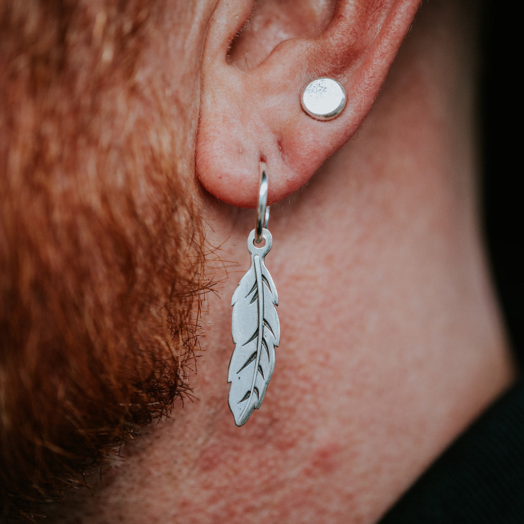 model wearing silver feather earring